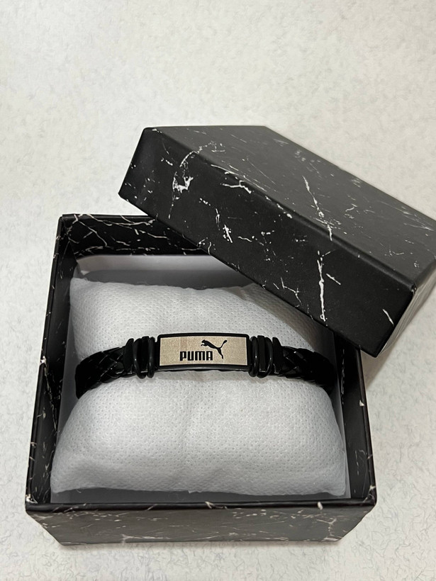 دستبند مردانه چرمی پوما (بافت پهن) – پلاک مستطیلی دو رنگ (نقرهای-مشکی) طرح نماد Puma و تایپوگرافی برند