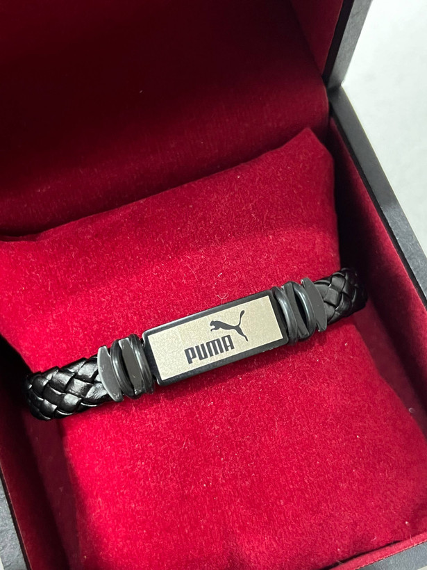 دستبند مردانه چرمی پوما (بافت پهن) – پلاک مستطیلی دو رنگ (نقرهای-مشکی) طرح نماد Puma و تایپوگرافی برند